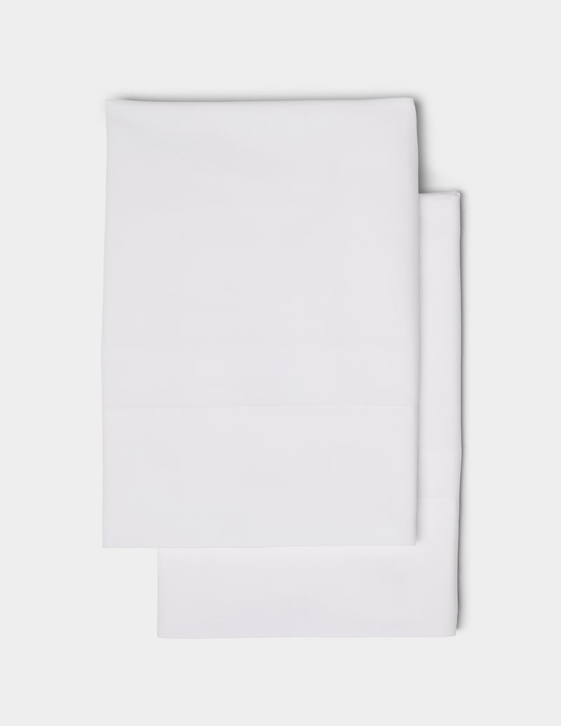 Two neatly folded Cozy Earth Soft-Wash Cotton Pillowcases are stacked on top of each other against a plain white background.