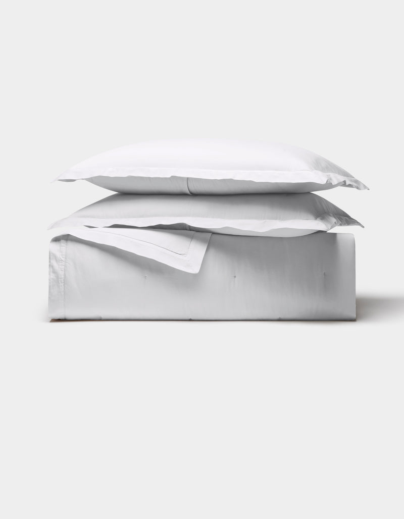 The Cozy Earth Soft-Wash Cotton Quilt Bundle is neatly folded with a pillow on top, showcased against a plain light gray background.