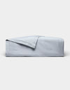 The Cozy Earth Soft-Wash Cotton Quilt, in light blue with a matching folded-back corner, is displayed on a plain white background.|Color:Shore