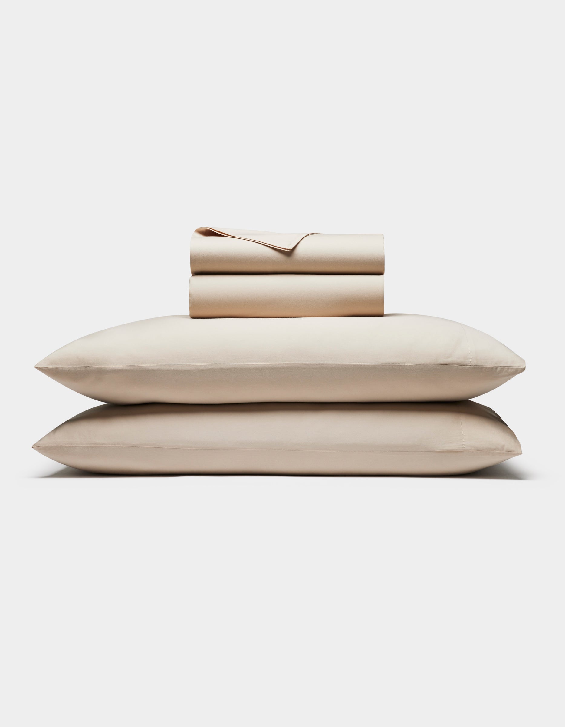 The Cozy Earth Soft-Wash Cotton Sheet Set is neatly folded with two stacked pillows at the bottom and matching sheets and pillowcases on top, all displayed against a plain white background.|Color:Driftwood