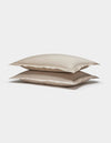 Two Soft-Wash Cotton Shams by Cozy Earth, in beige, are stacked neatly together against a plain white background.|Color:Driftwood