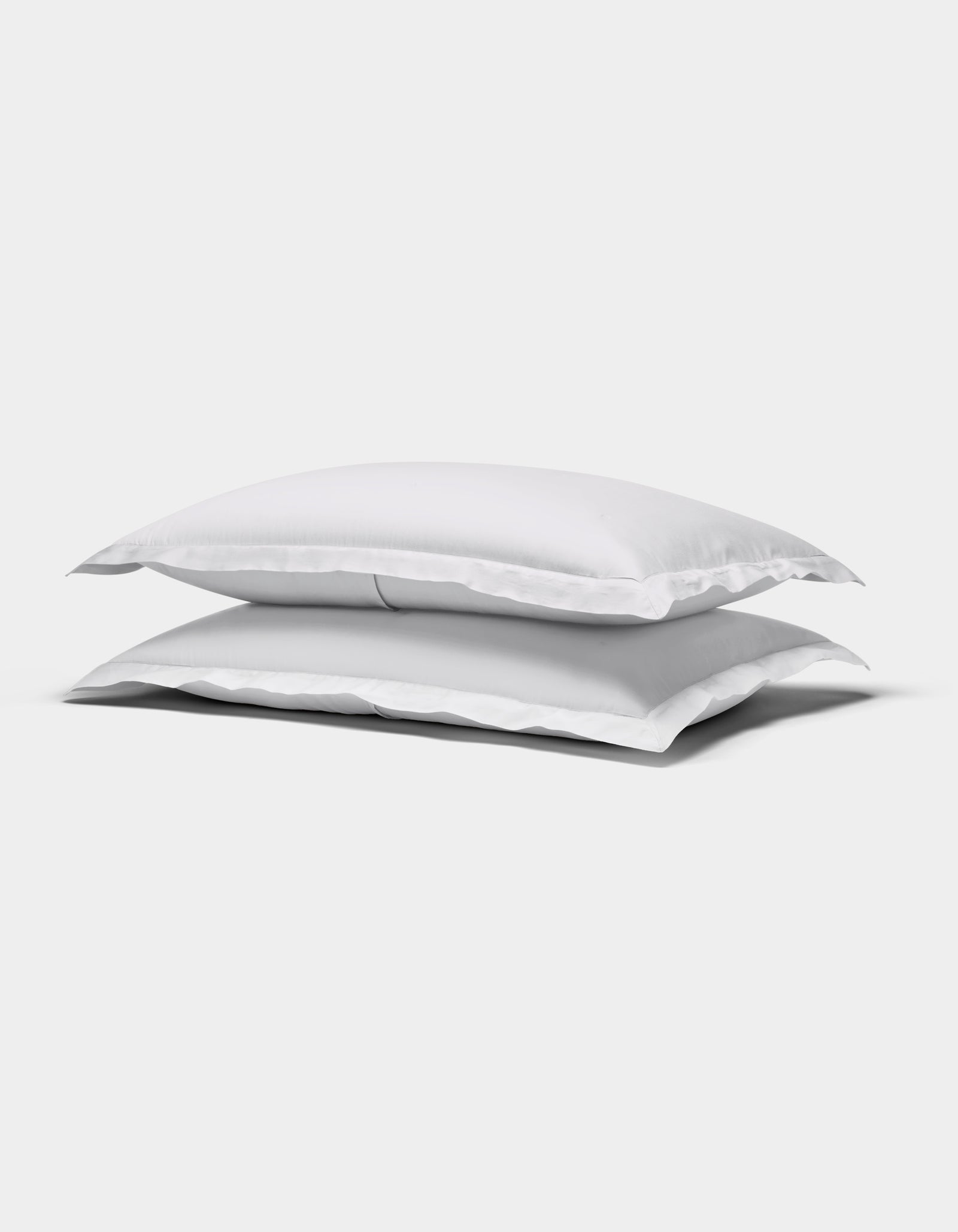 Two Cozy Earth Soft-Wash Cotton Quilted Shams, rectangular and white, are stacked atop each other against a plain white background.