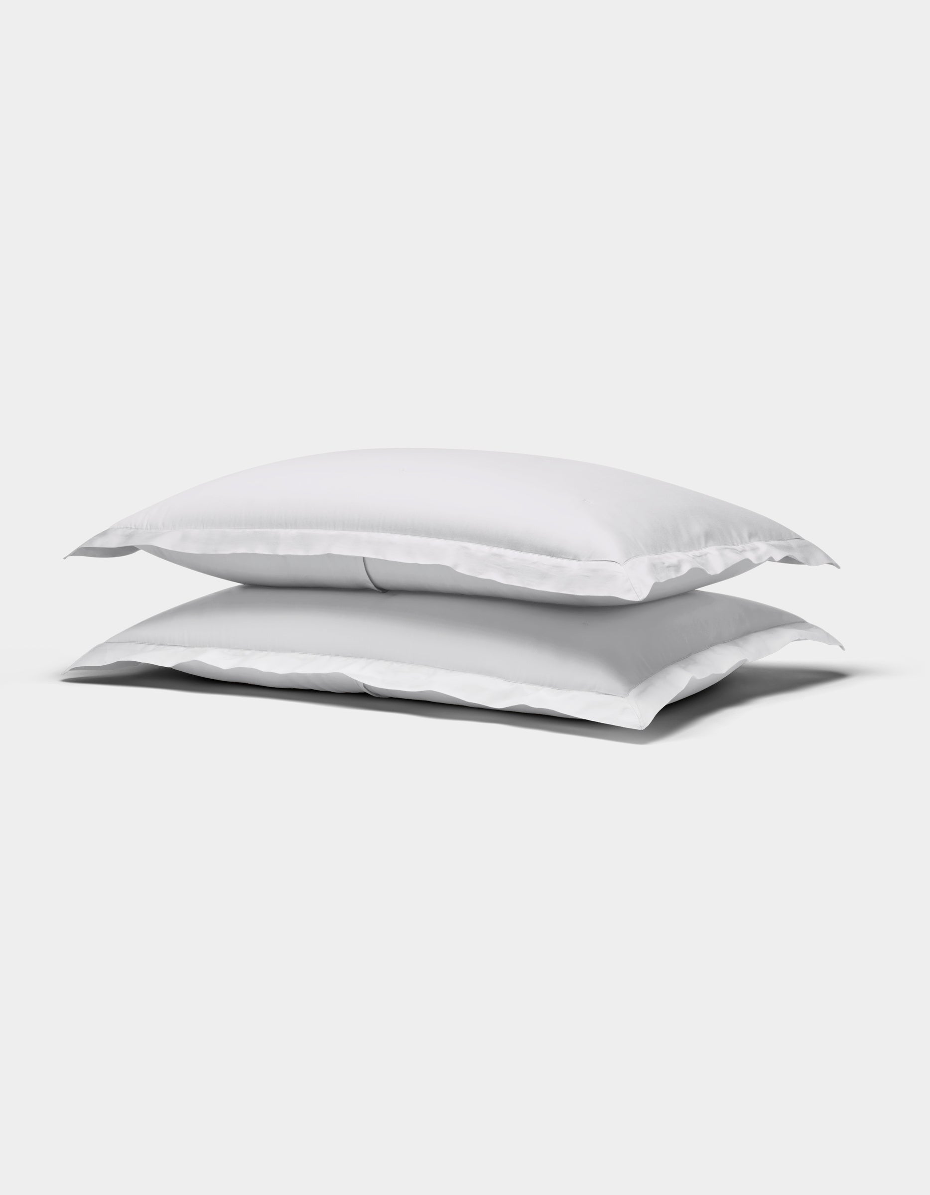Two Cozy Earth Soft-Wash Cotton Quilted Shams, rectangular and white, are stacked atop each other against a plain white background.|Color:White