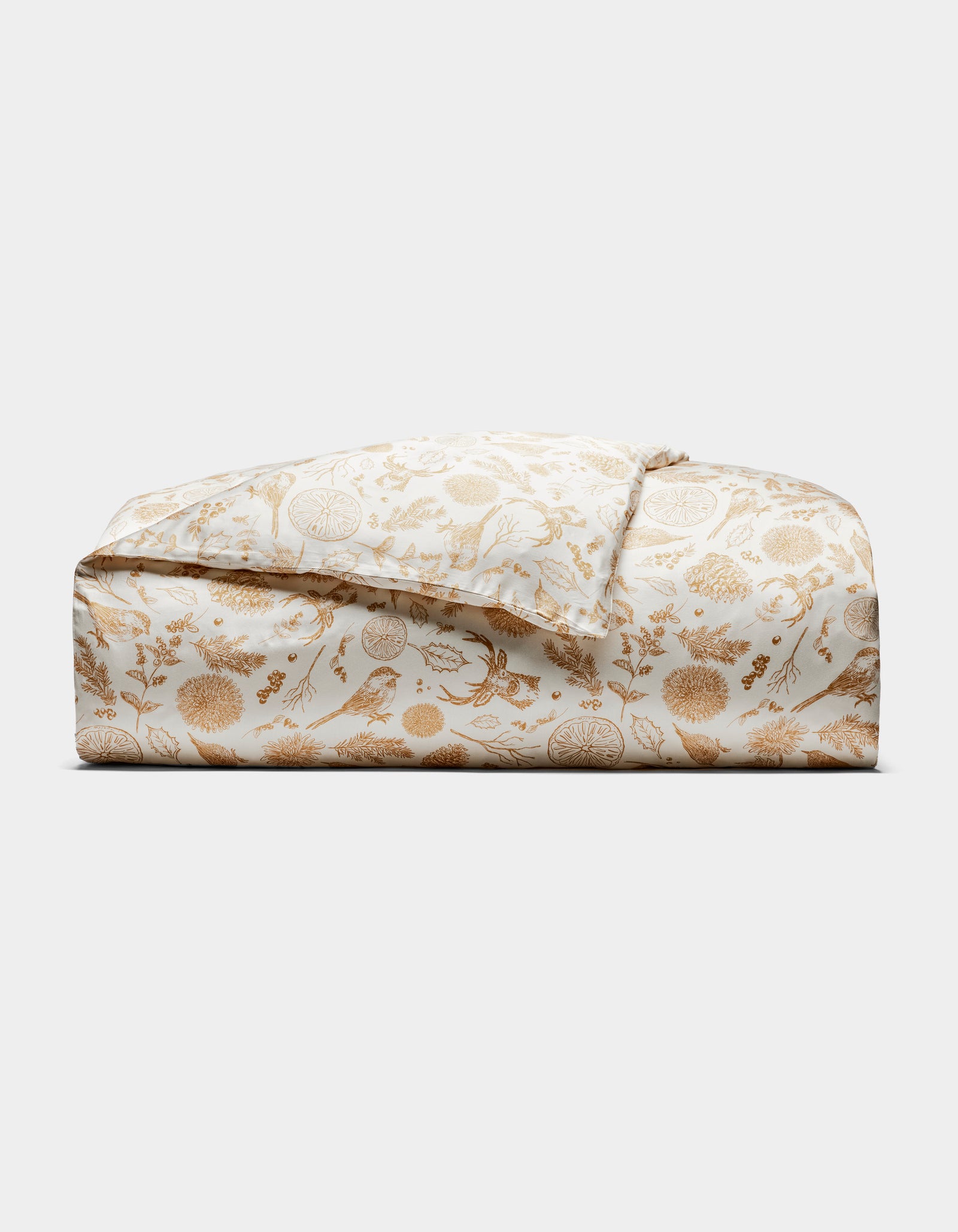 The Bamboo Duvet Cover by Cozy Earth is shown folded, featuring a white background with a gold floral and botanical print of detailed flowers, leaves, and birds, displayed against a plain white background.