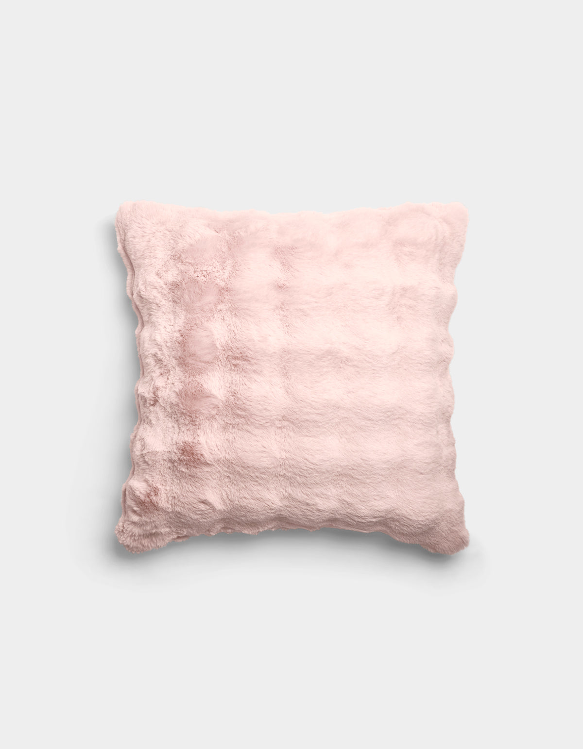 The Bubble Cuddle Pillow by Cozy Earth is a square, pale pink plush pillow with a soft, fuzzy texture and subtle horizontal ridges, shown against a plain light gray background.