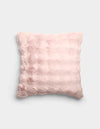 The Bubble Cuddle Pillow by Cozy Earth is a square, pale pink plush pillow with a soft, furry texture and subtle horizontal ridges, shown against a plain light gray background.|Color:Blossom