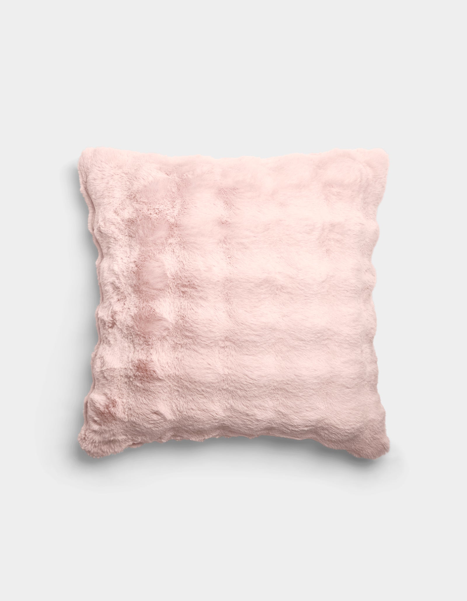 The Bubble Cuddle Pillow by Cozy Earth is a square, pale pink plush pillow with a soft, furry texture and subtle horizontal ridges, shown against a plain light gray background.