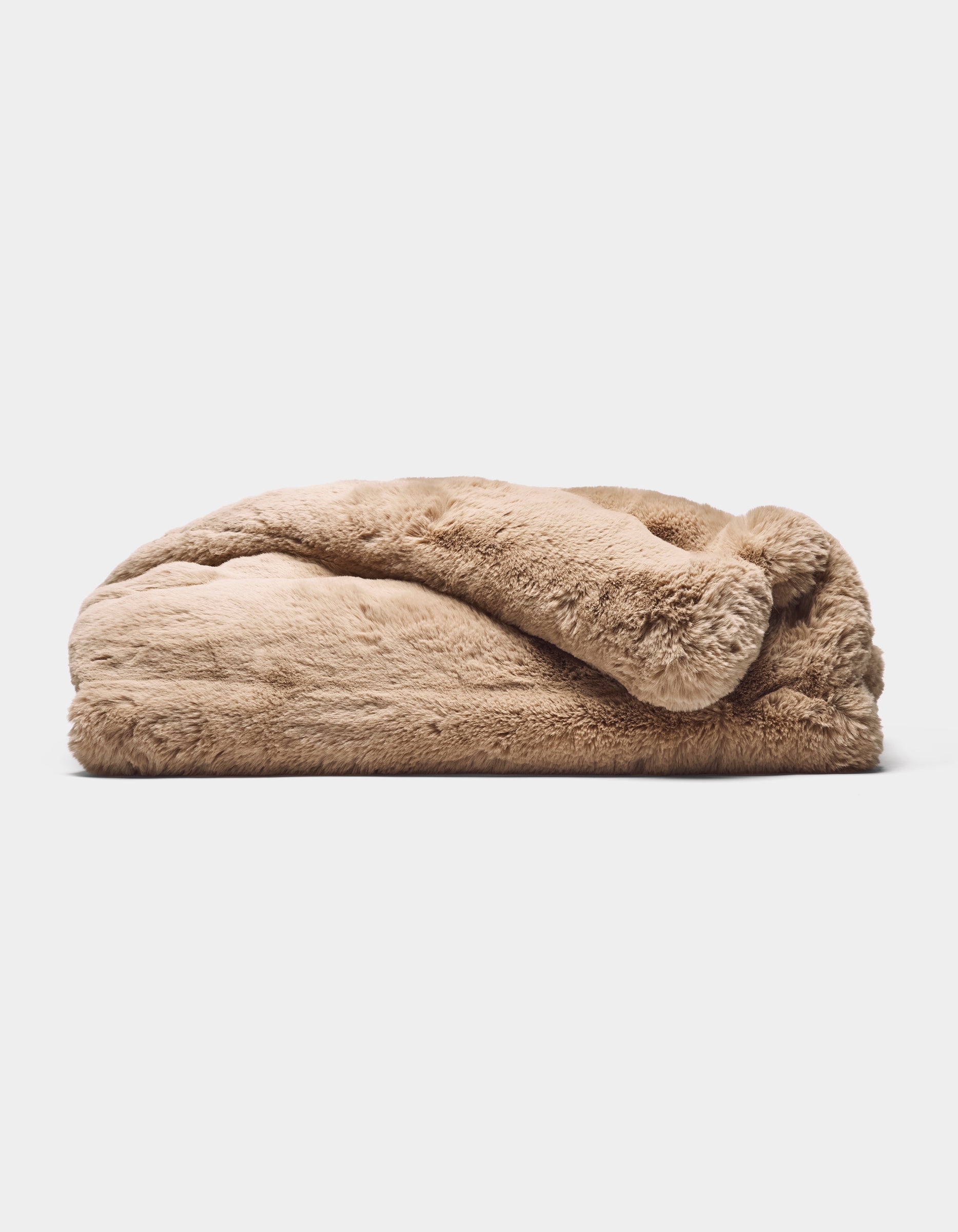 The Cozy Earth Channel Cuddle Blanket, featuring fluffy tan-colored faux fur, is folded and displayed on a flat surface against a plain white background.