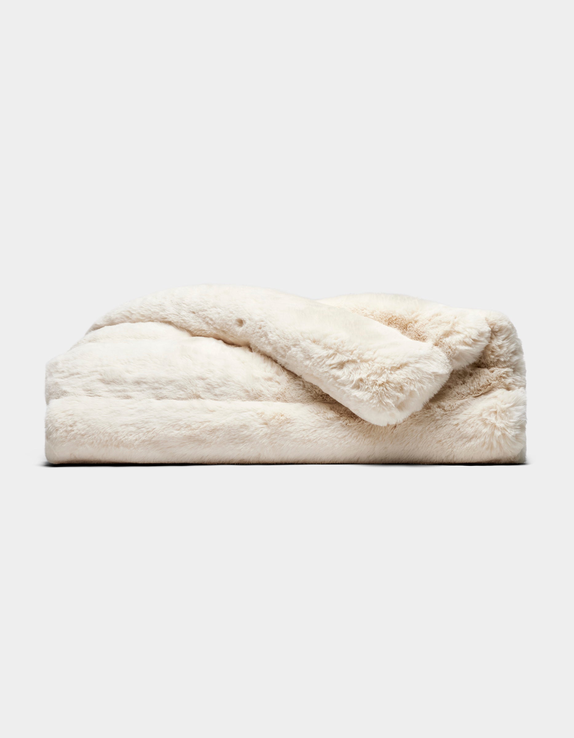 The Cozy Earth Channel Cuddle Blanket, featuring plush off-white faux fur, is neatly folded and displayed against a plain light gray background.|Color:Creme