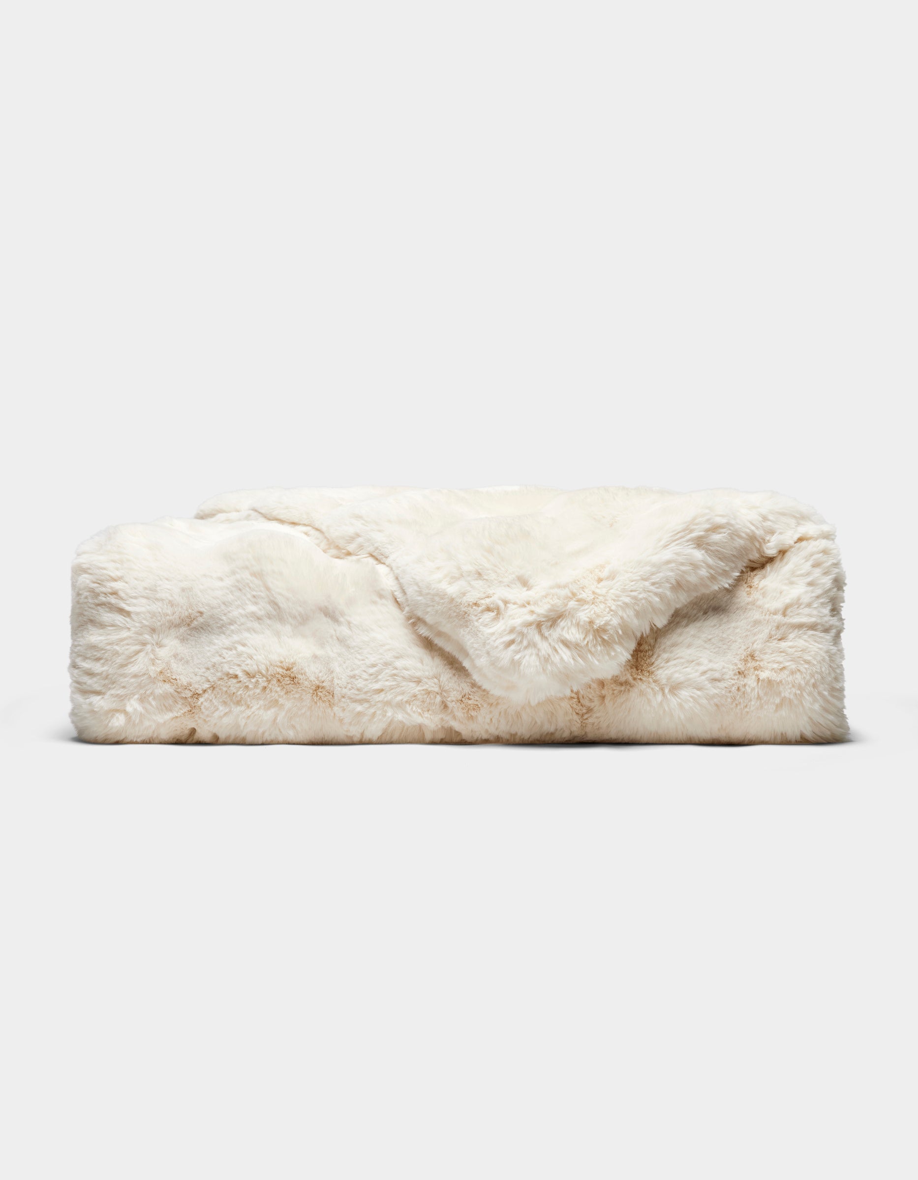 The Double Bubble Cuddle Blanket by Cozy Earth, featuring soft, cream-colored faux fur, is neatly folded on a plain light gray background.|Color:Creme