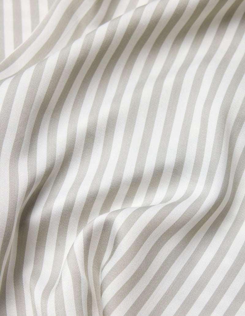 A close-up of the Cozy Earth Bamboo Sheet Set shows soft, white fabric with light gray vertical stripes, gentle folds, and a smooth texture.