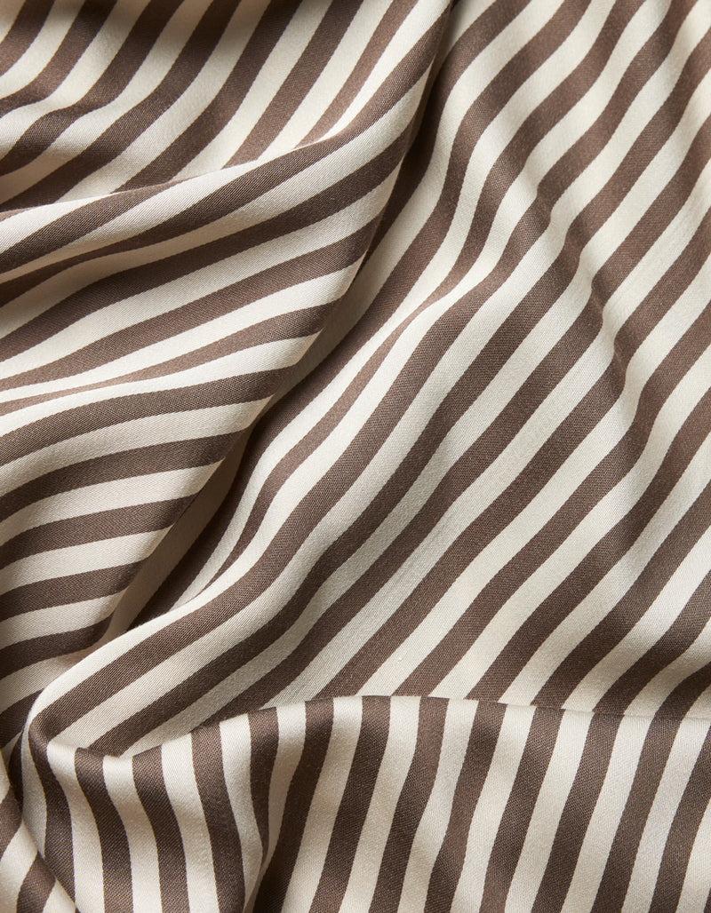 Close-up of Cozy Earth’s Bamboo Sheet Set fabric, featuring diagonal brown and white stripes with soft folds and a smooth texture that creates a dynamic, wavy effect across the material.