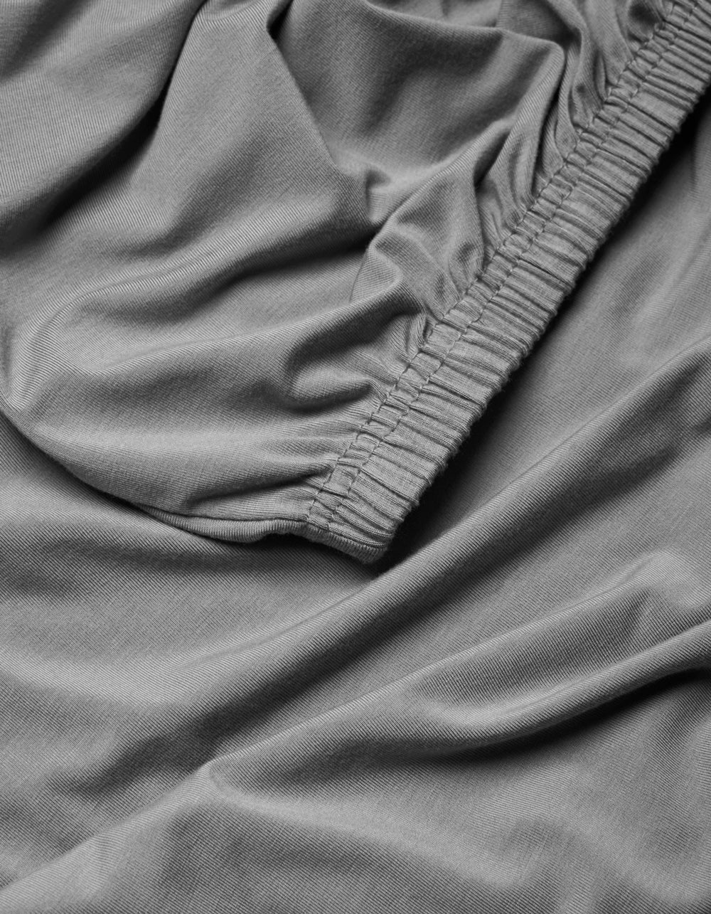 Close-up of the Cozy Earth Bamboo Jersey Fitted Sheet, highlighting the gathered elastic edge and the ultra-soft, smooth fabric texture.|Color:Stone