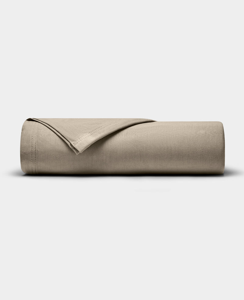 A Cozy Earth Bamboo Jersey Flat Sheet in beige is neatly folded and displayed on a plain, light gray background.