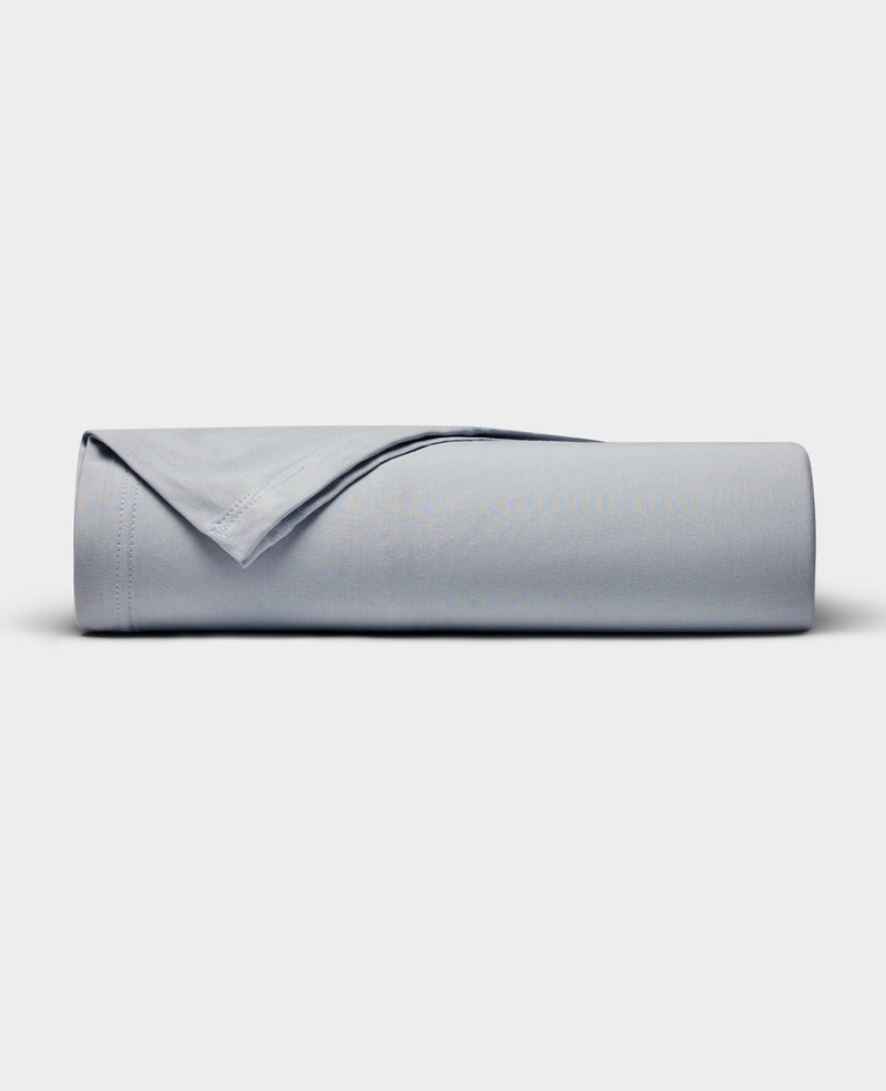 The Cozy Earth Bamboo Jersey Flat Sheet is neatly rolled with a folded edge and displayed on a plain white background.