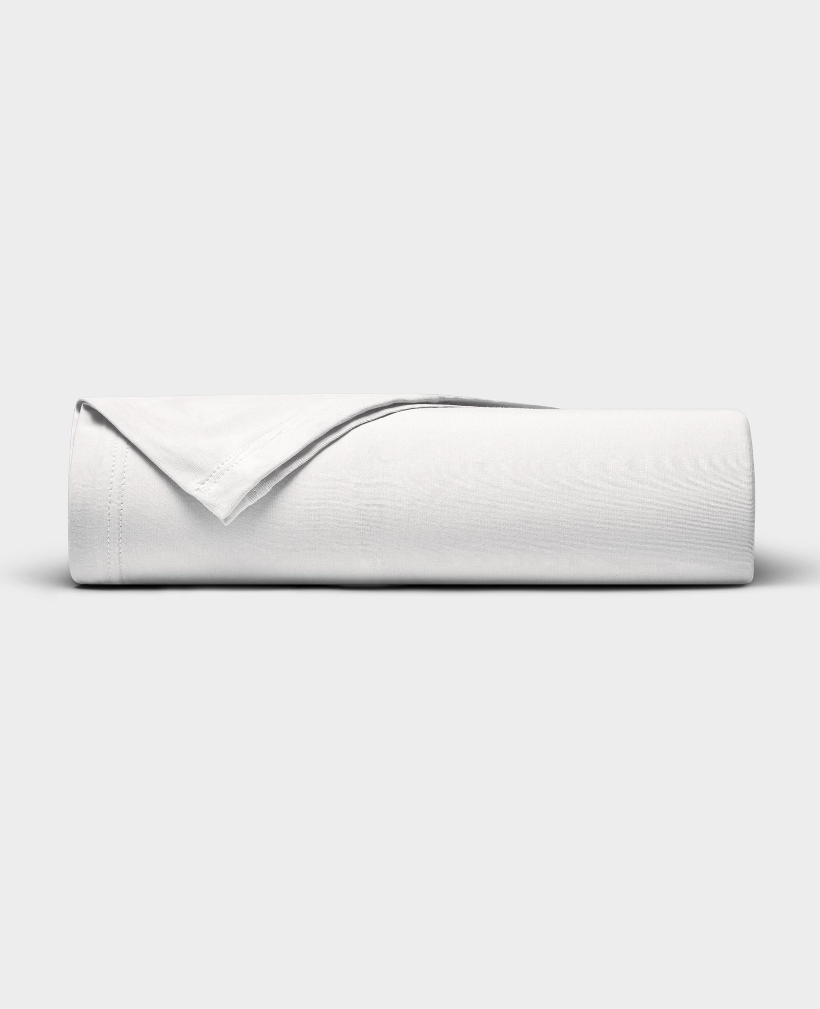 The Cozy Earth Bamboo Jersey Flat Sheet is neatly folded with a corner turned back, showcased against a plain light gray background.