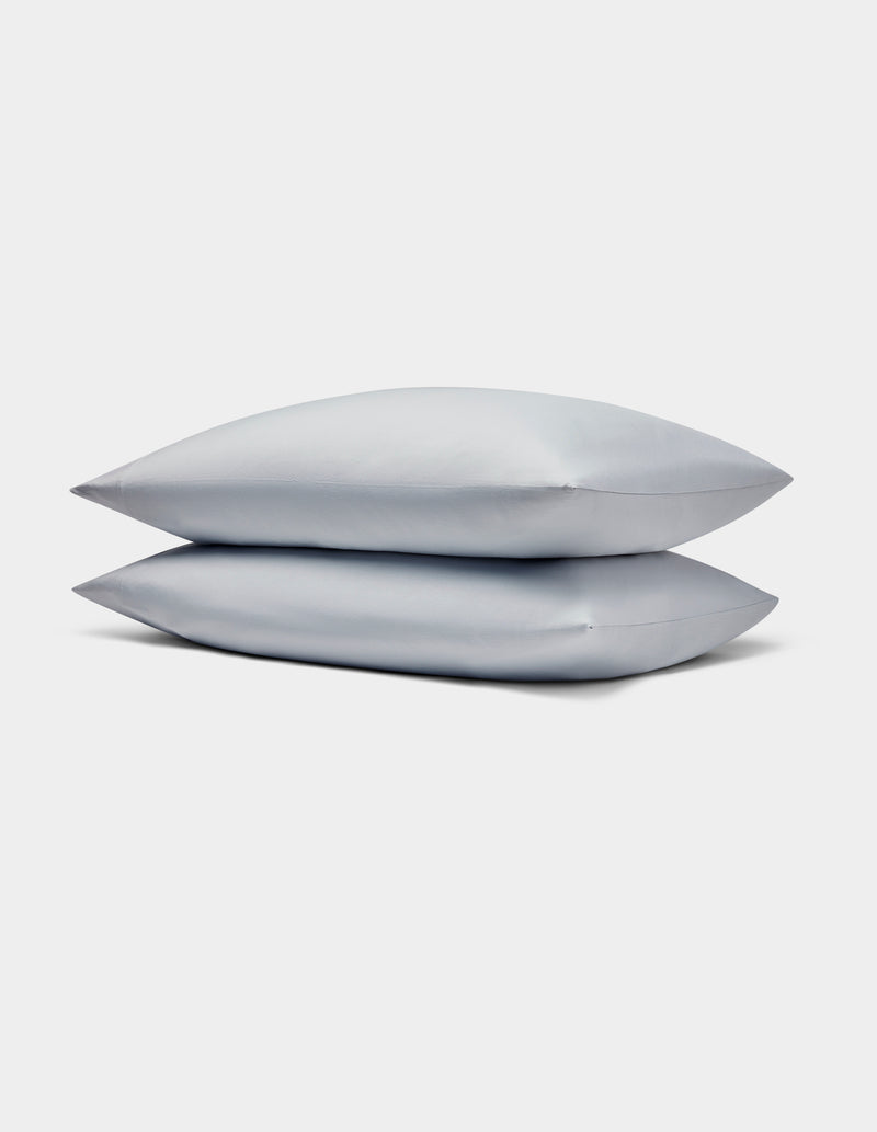 Two light gray Bamboo Jersey Pillowcases by Cozy Earth stacked neatly on each other against a plain white background.