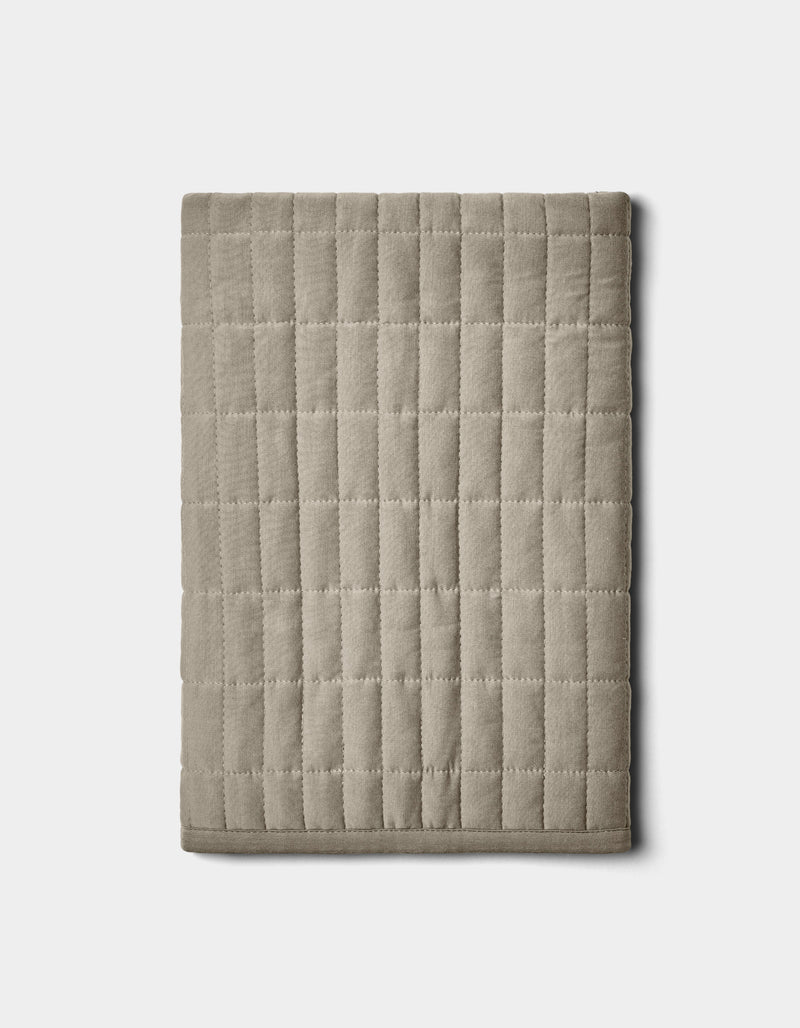 The Cozy Earth Bamboo Jersey Quilted Shams in beige feature a square grid pattern and are displayed folded on a plain white background.