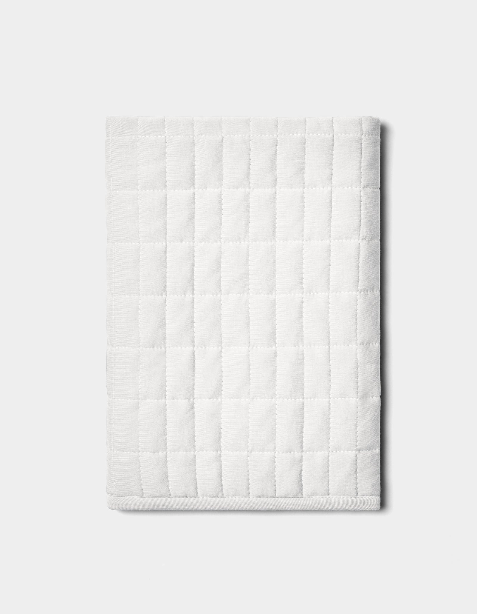 The Bamboo Jersey Quilted Shams by Cozy Earth are neatly folded with a square pattern and displayed on a plain light gray background.