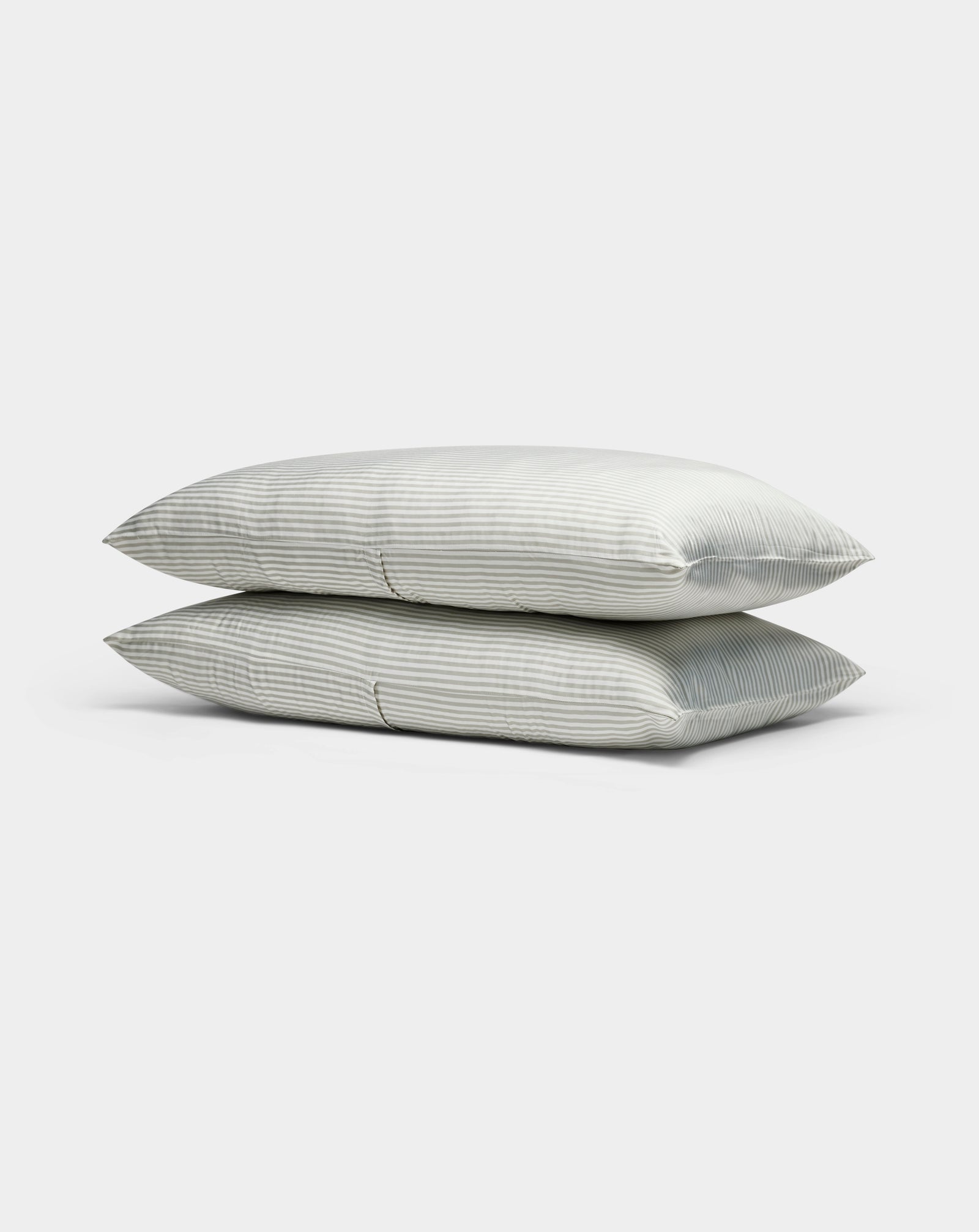 Two light gray, striped Cozy Earth Bamboo Pillowcases are stacked neatly atop each other against a plain white background.