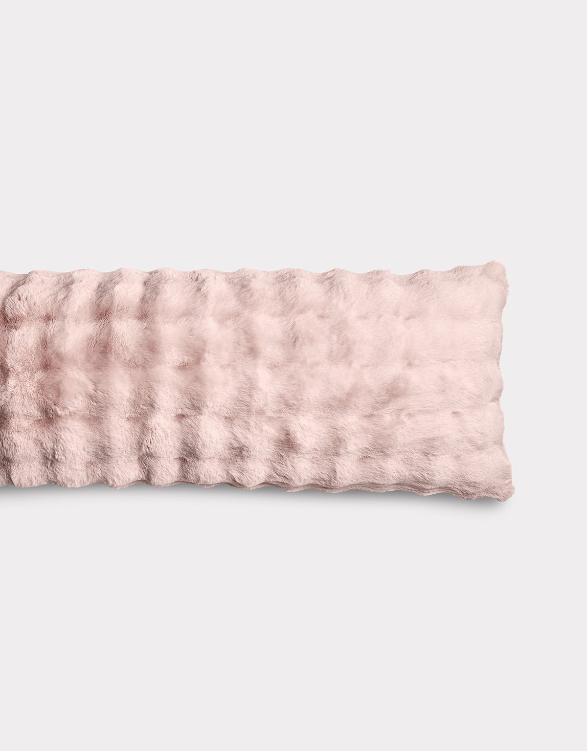 The Bubble Cuddle Pillow by Cozy Earth is a soft, light pink rectangular pillow with a plush, wavy-textured surface, displayed against a plain light background.|Color:Blossom |Size:Body