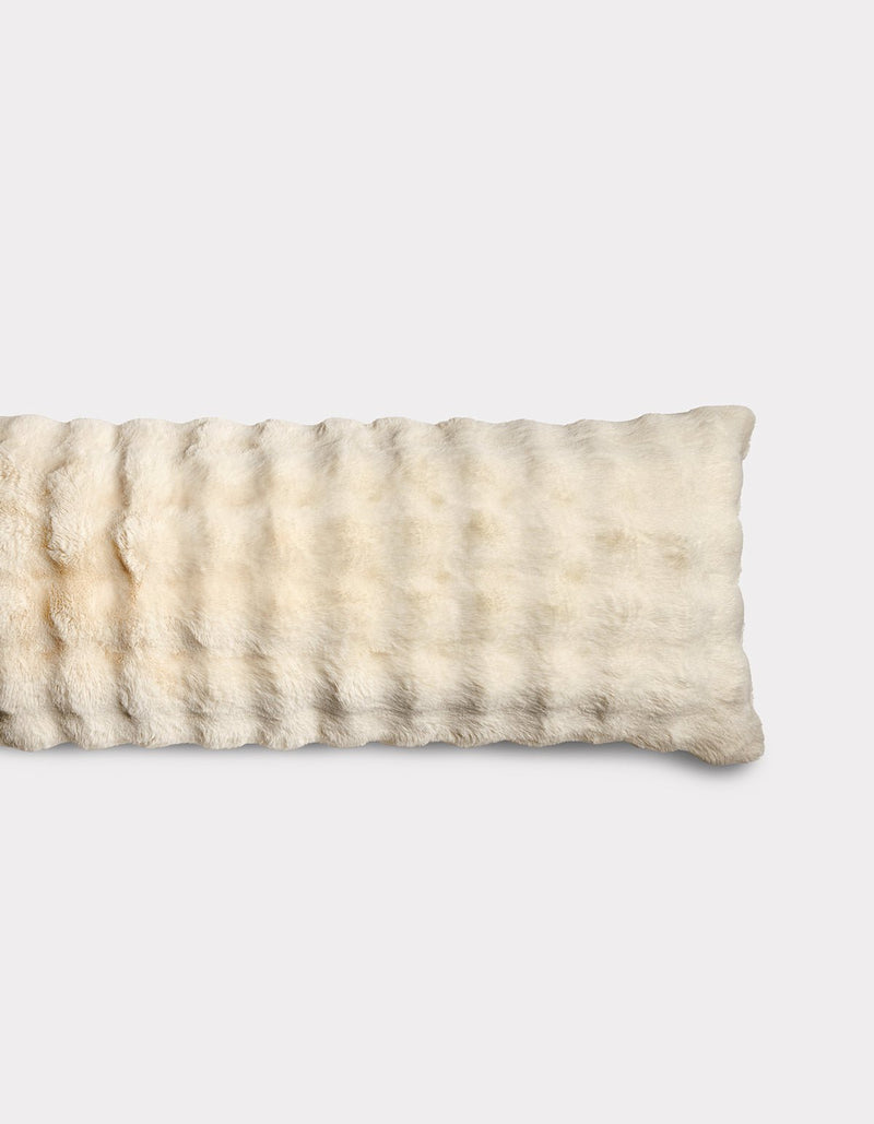 The Bubble Cuddle Pillow by Cozy Earth is a rectangular, cream-colored plush pad with a soft, furry texture, shown lying flat on a plain white background.