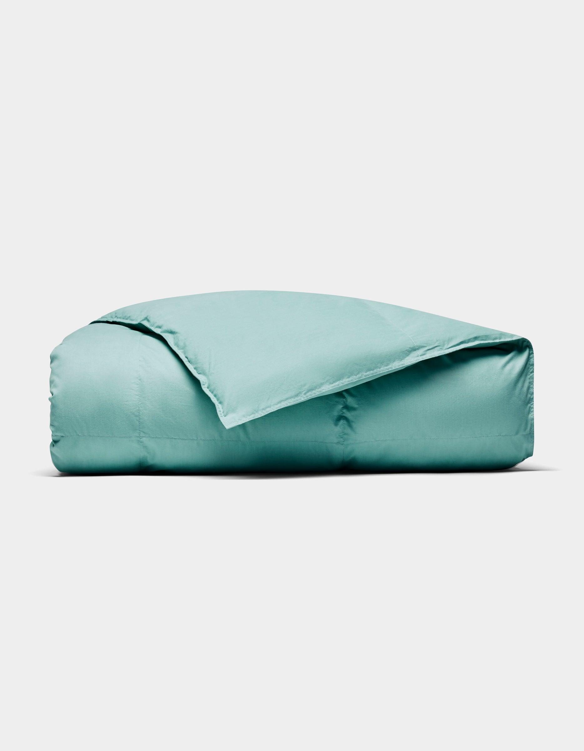 The Cozy Earth Down Alternative Throw, in light teal, is neatly folded and displayed against a plain white background.|Color:Pond