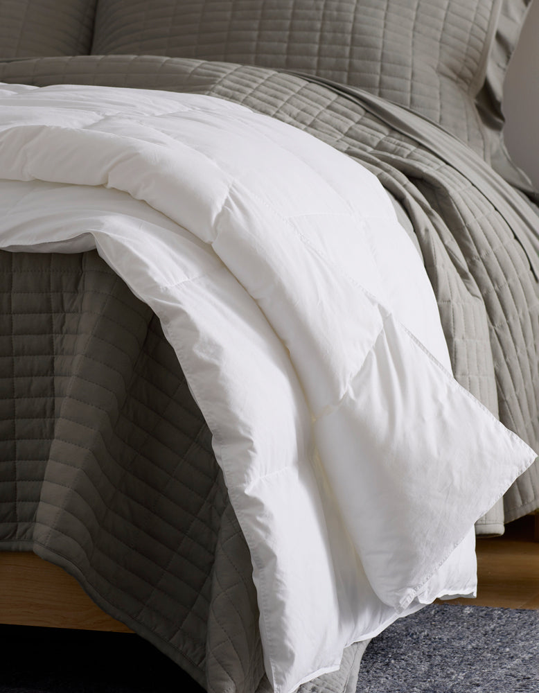 White comforter on a bed with gray bedding