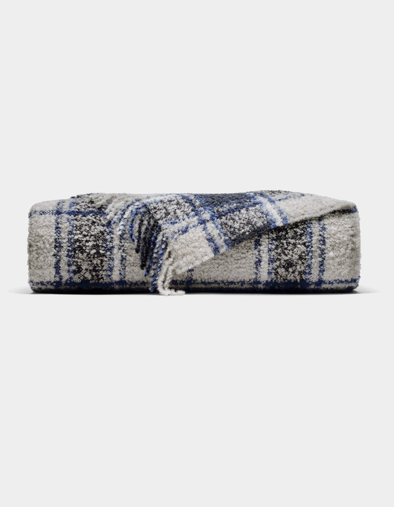 The Cozy Earth Alpaca Boucle Throw is a soft, gray blanket with a blue and white plaid pattern. Displayed against a plain background, one corner is partially unfolded to showcase its unique texture and design.