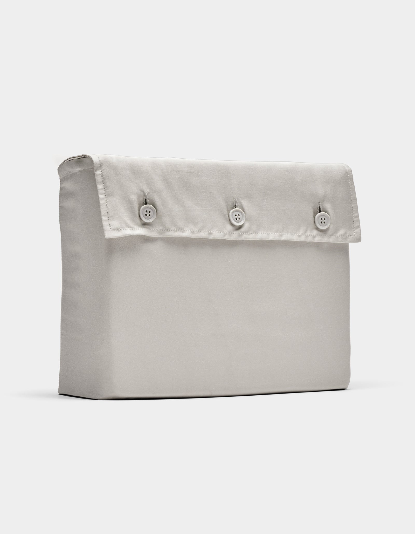 The Cozy Earth Bamboo Sheet Set, shown in light beige, is displayed folded with a rectangular fabric pouch and flap secured by three front buttons, photographed against a plain white background.