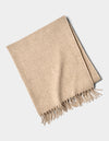 The Cozy Earth Lucia Throw is a neatly folded beige woven blanket with tasseled fringe on one edge, displayed on a plain white background.|Color:Grain