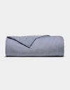 The Cozy Earth Bamboo Duvet Cover, featuring navy blue and white vertical stripes, is neatly folded and displayed against a plain light gray background.|Color:Classic Stripe in Pacific