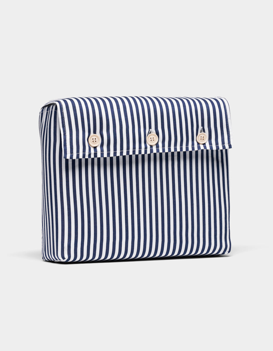 The Bamboo Duvet Cover packaging by Cozy Earth features vertical navy blue and white stripes and a flap closure secured by four light-colored buttons on the front.