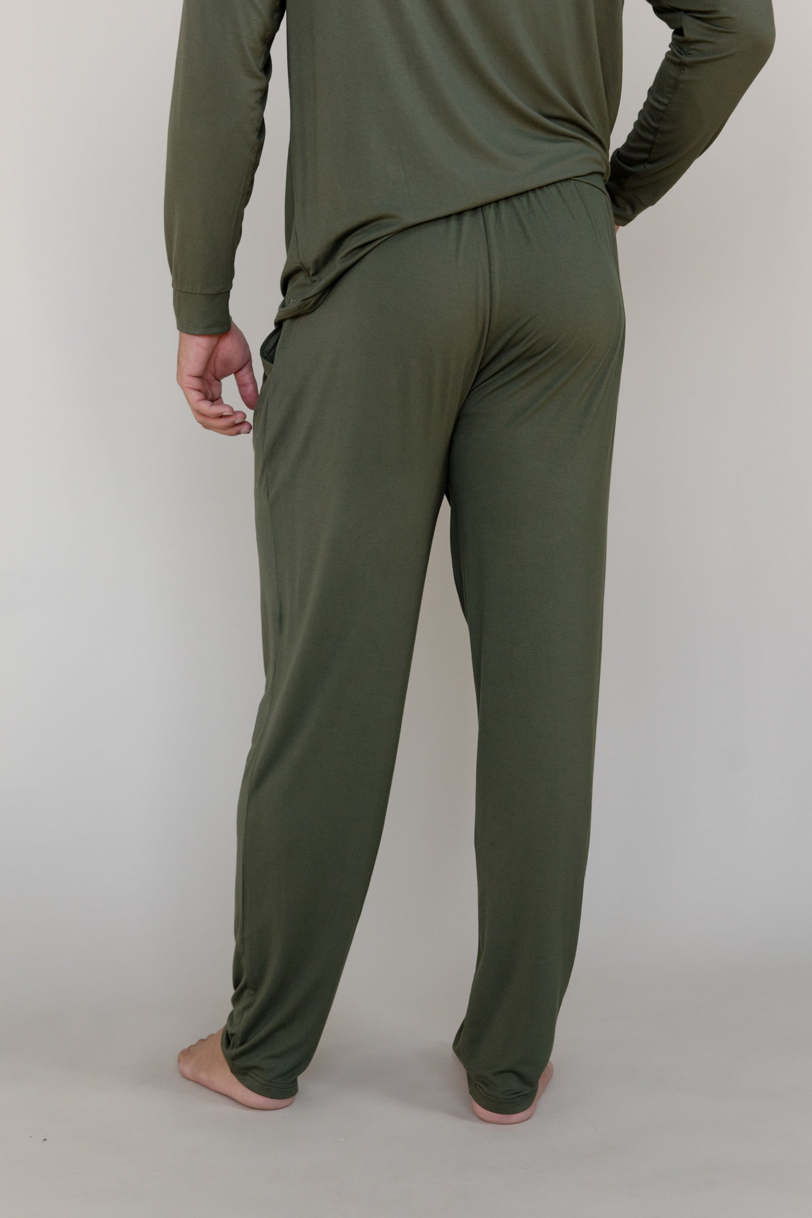 Back of man in olive long sleeve pajama pants with white background 