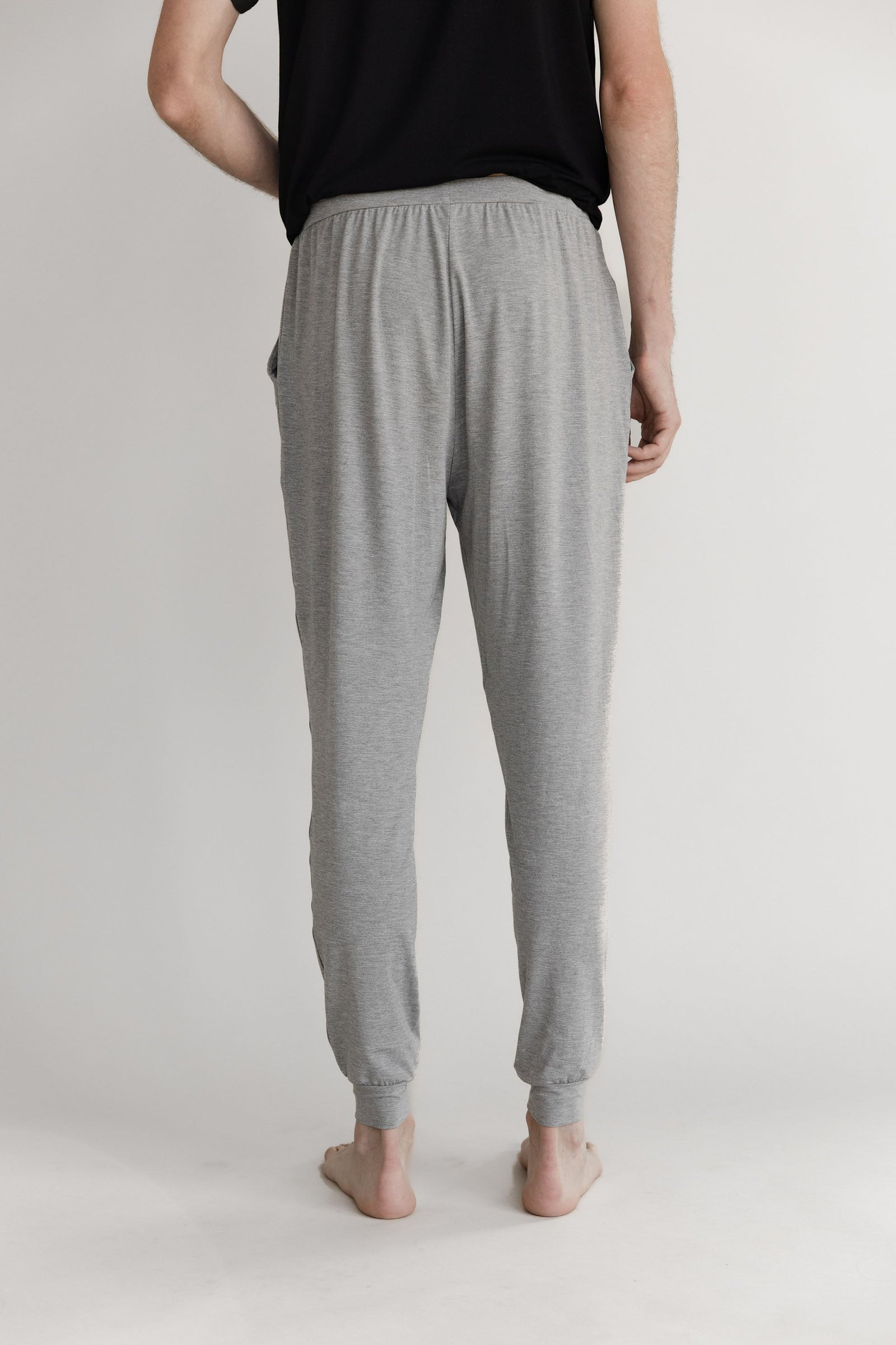 Man in heather grey pajama joggers with white background 