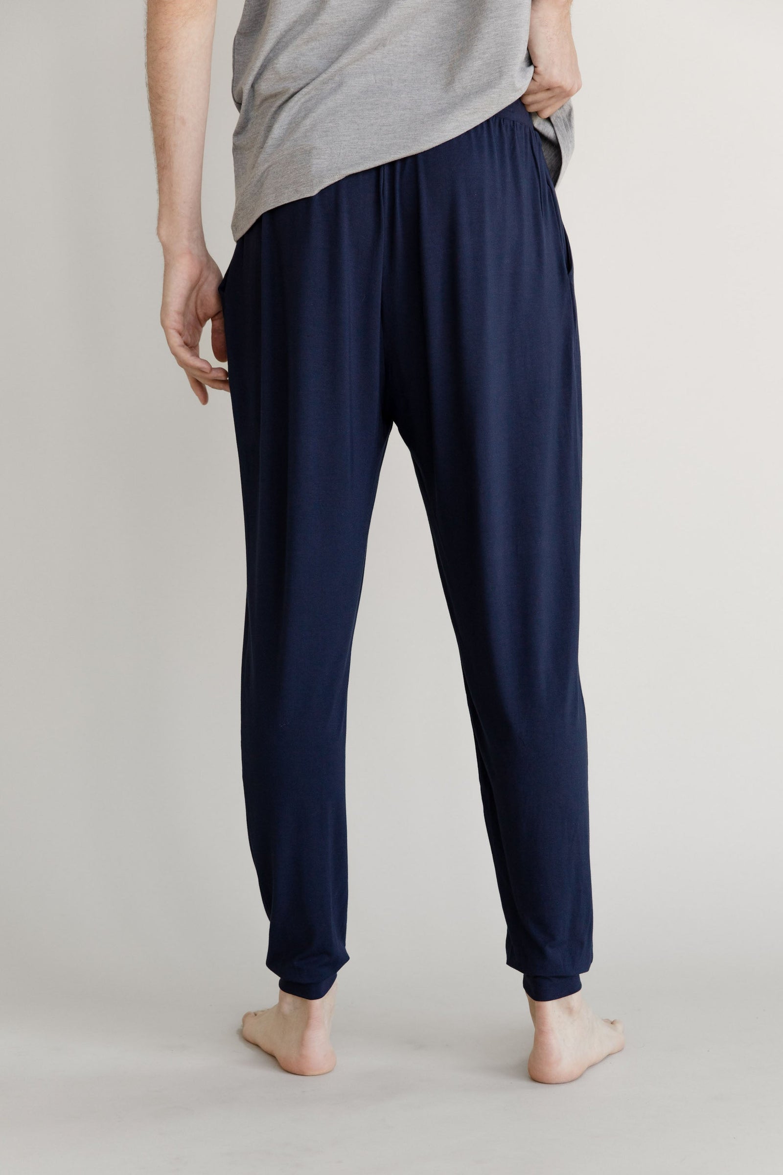 Man in navy pajama joggers with white background 