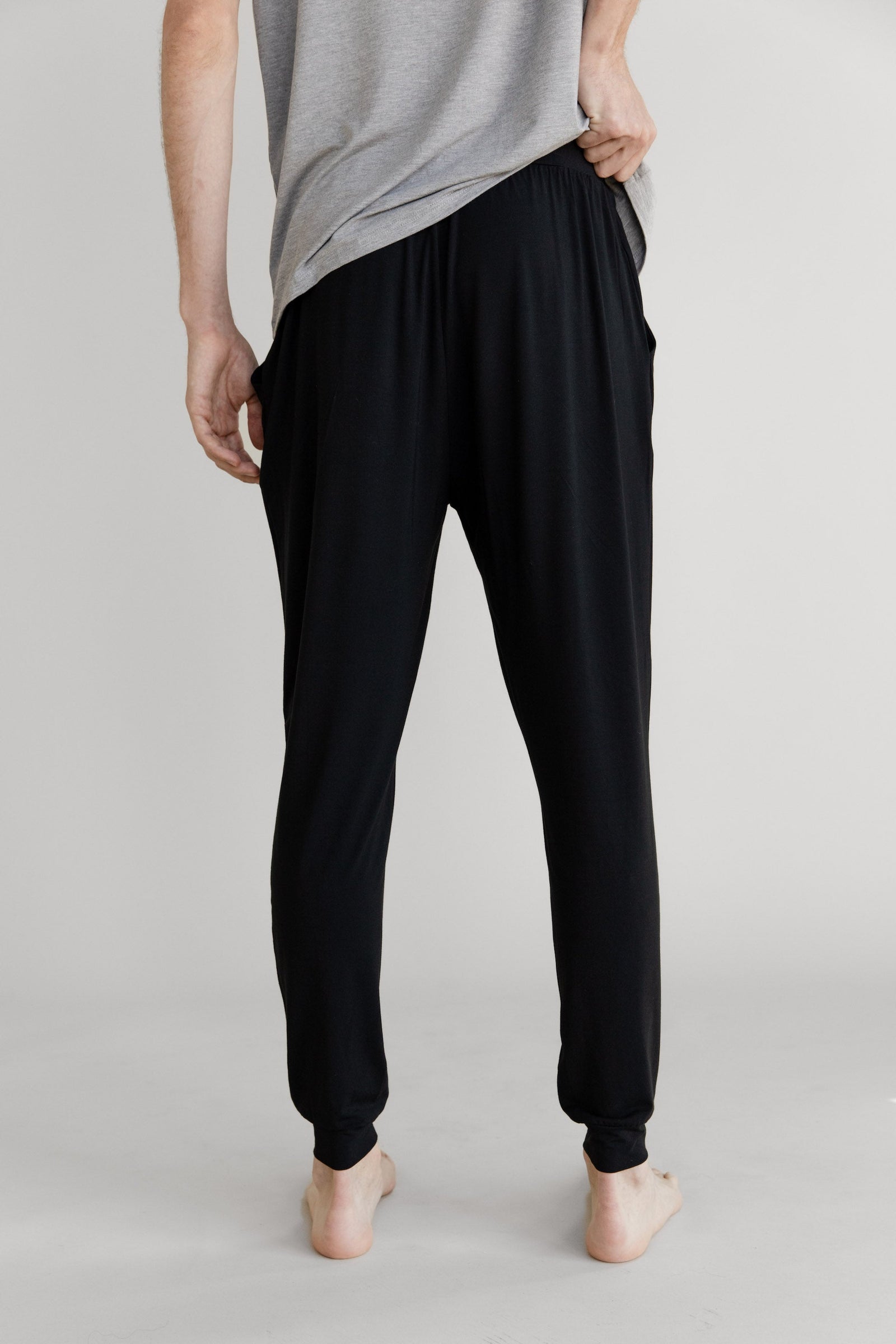 Man in black pajama joggers with white background 