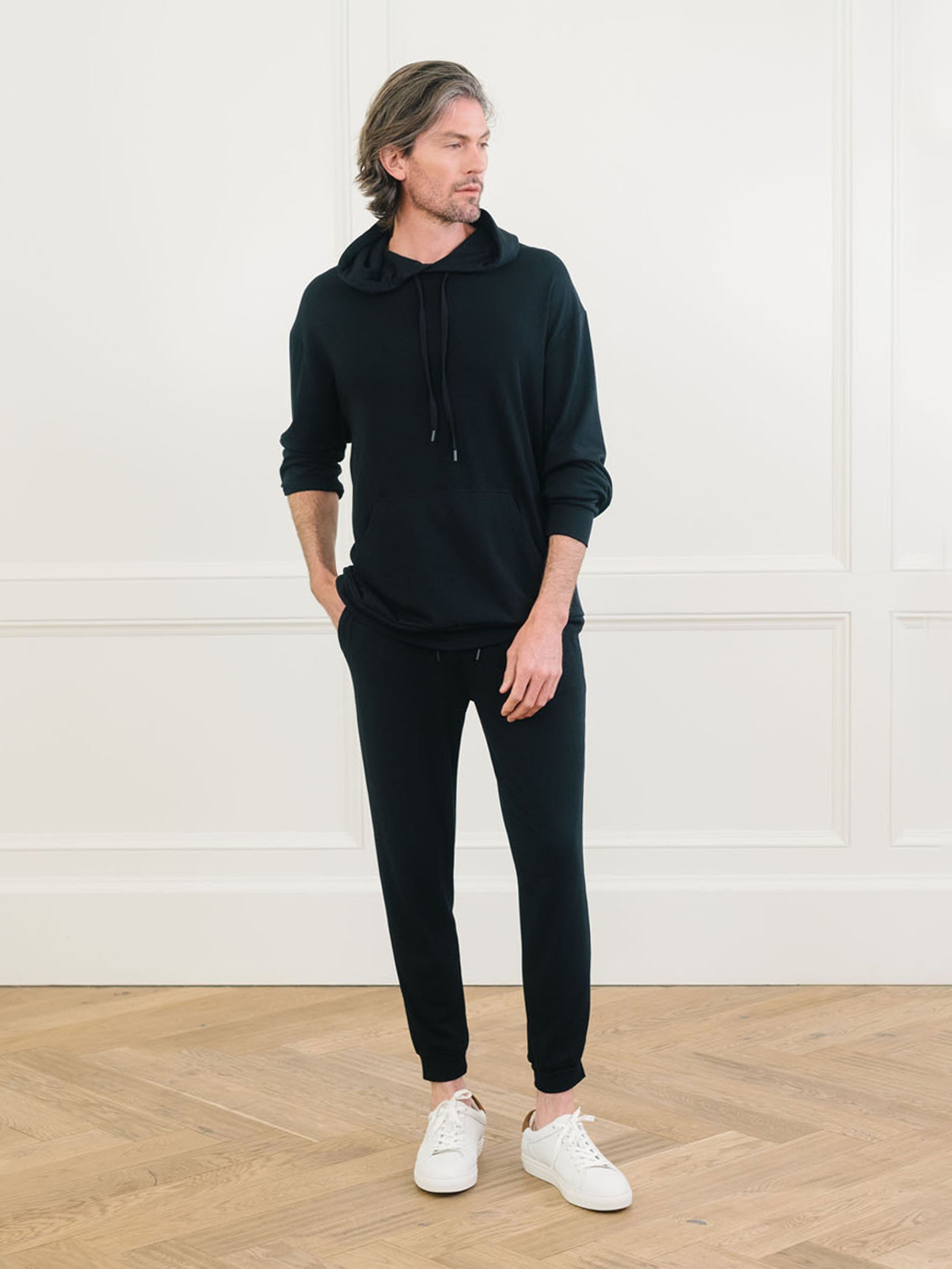 A man wears Men's Brushed Bamboo Hoodie & Jogger Set in Black. 