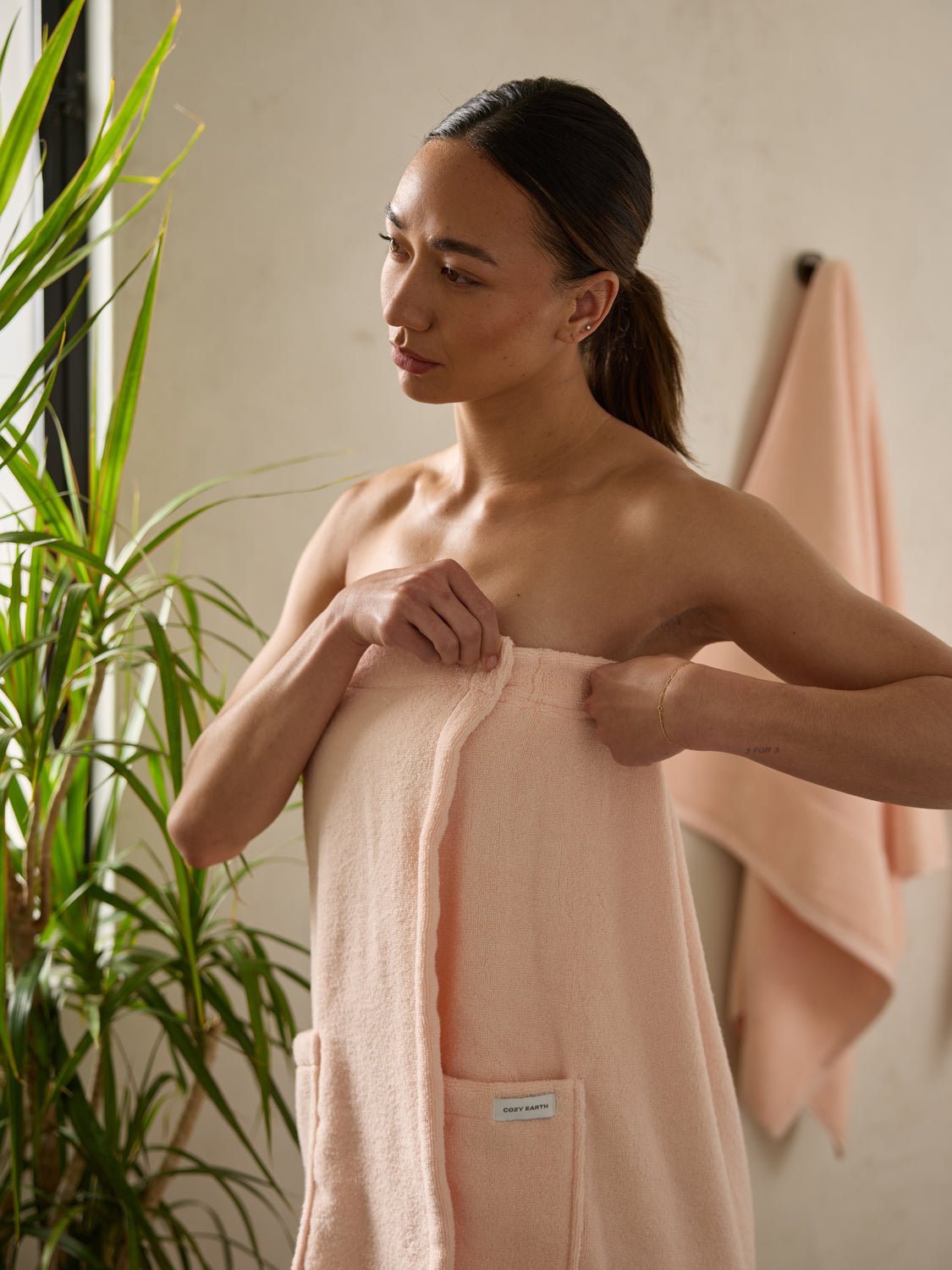 Woman in bathroom wearing pink towel wrap 