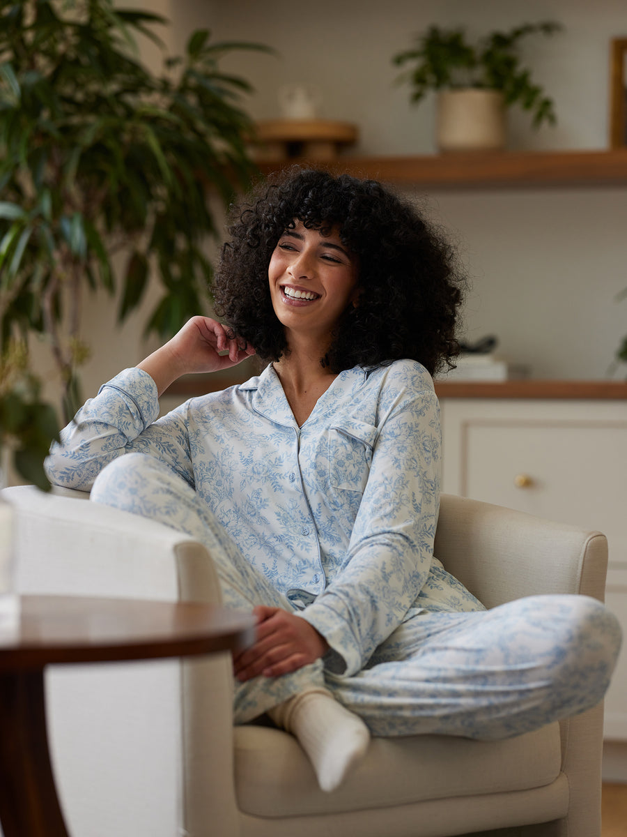 Woman sitting in living room in blue toile pajama set |Color:Blue Toile