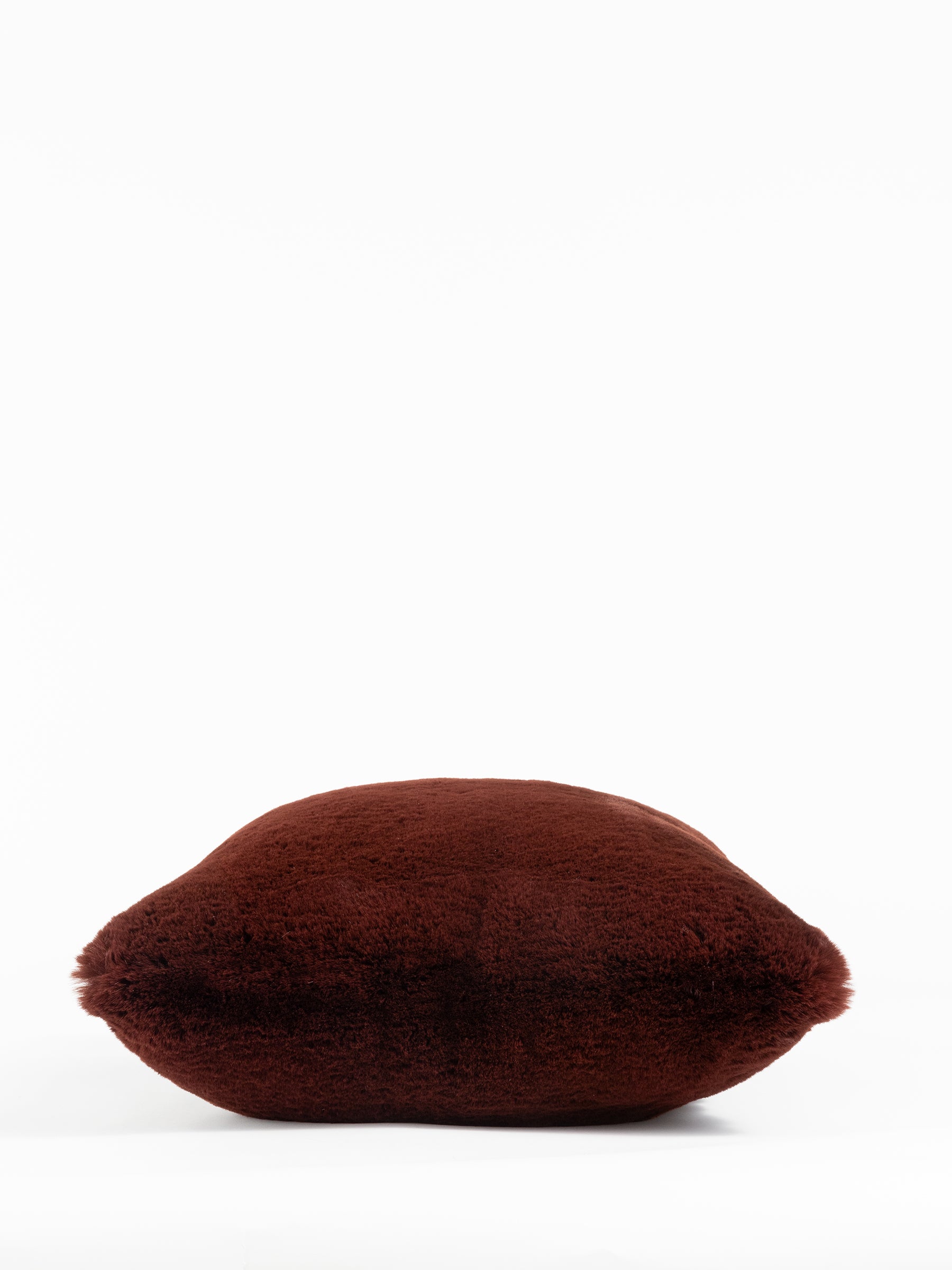 A soft, fluffy Cuddle Pillow in dark brown by Cozy Earth is centered against a plain white background. |Color:Burgundy