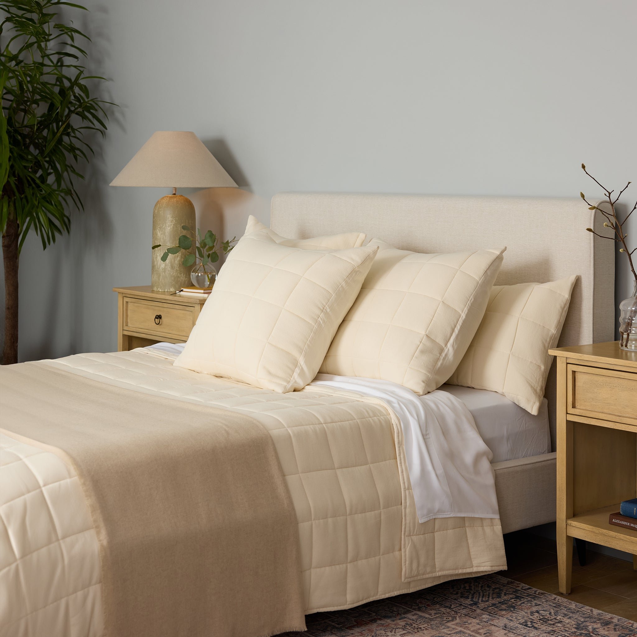 Buttermilk Aire Bamboo Box Quilt Euro Sham. The sham is resting on a bed in a bedroom