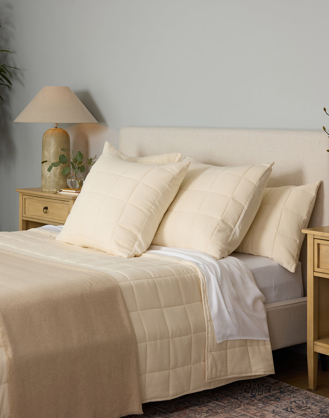 Buttermilk Aire Bamboo Box Quilt Euro Sham. The sham is resting on a bed in a bedroom