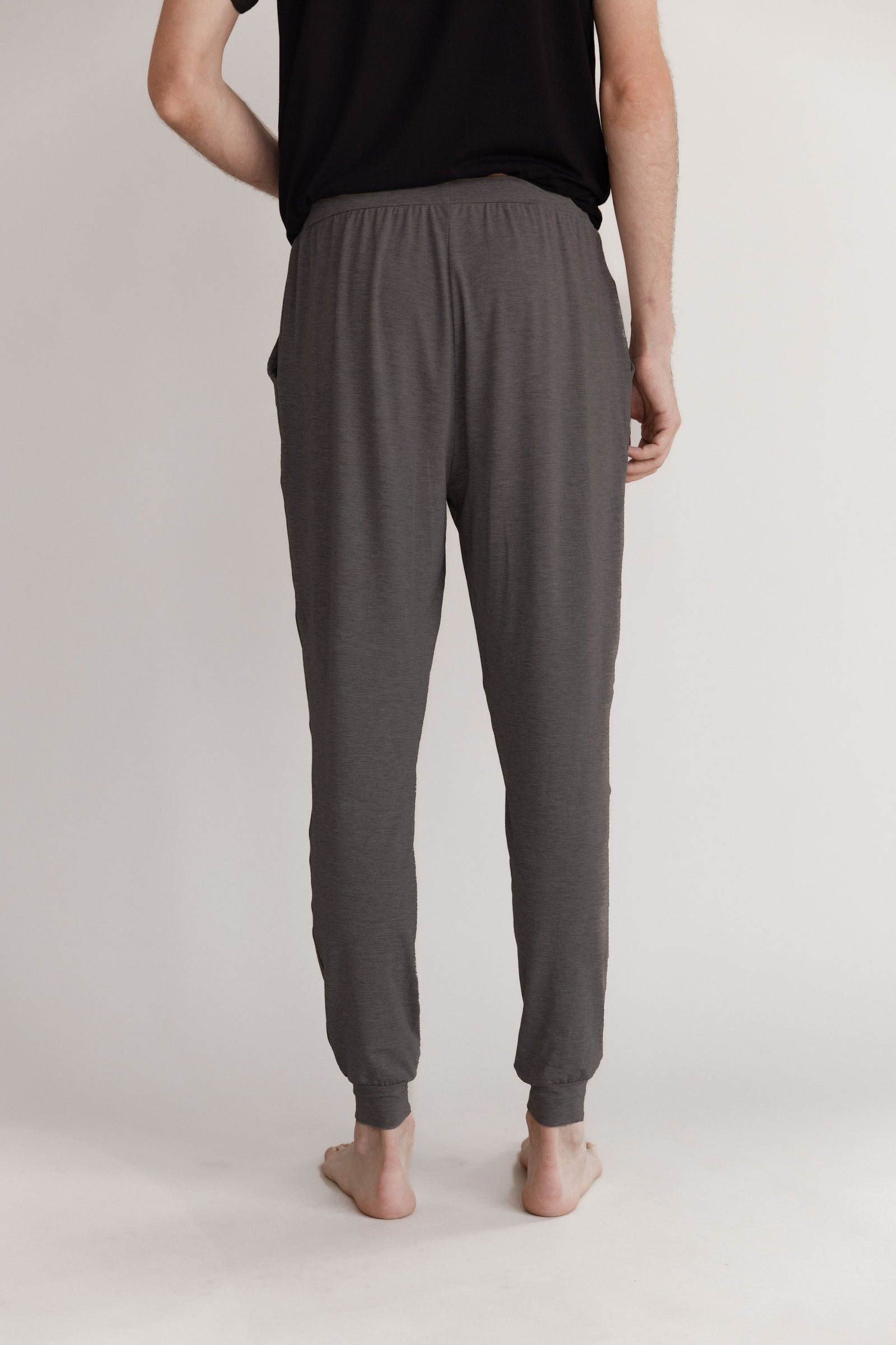 Man in charcoal pajama joggers with white background 