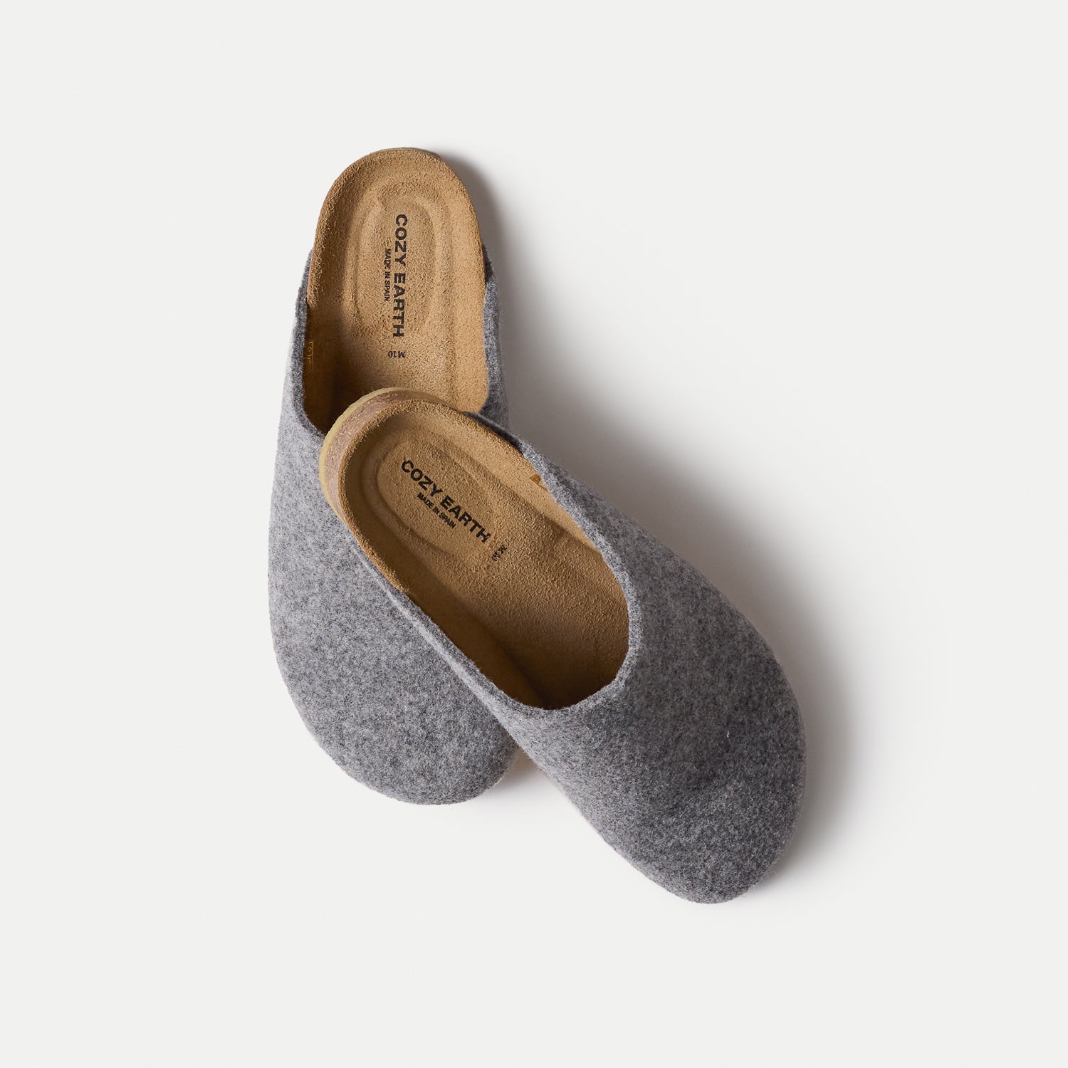 A pair of Lakehouse Clog slip-on slippers by Cozy Earth features a gray, soft-textured fabric exterior and brown insoles, set against a plain light background. 