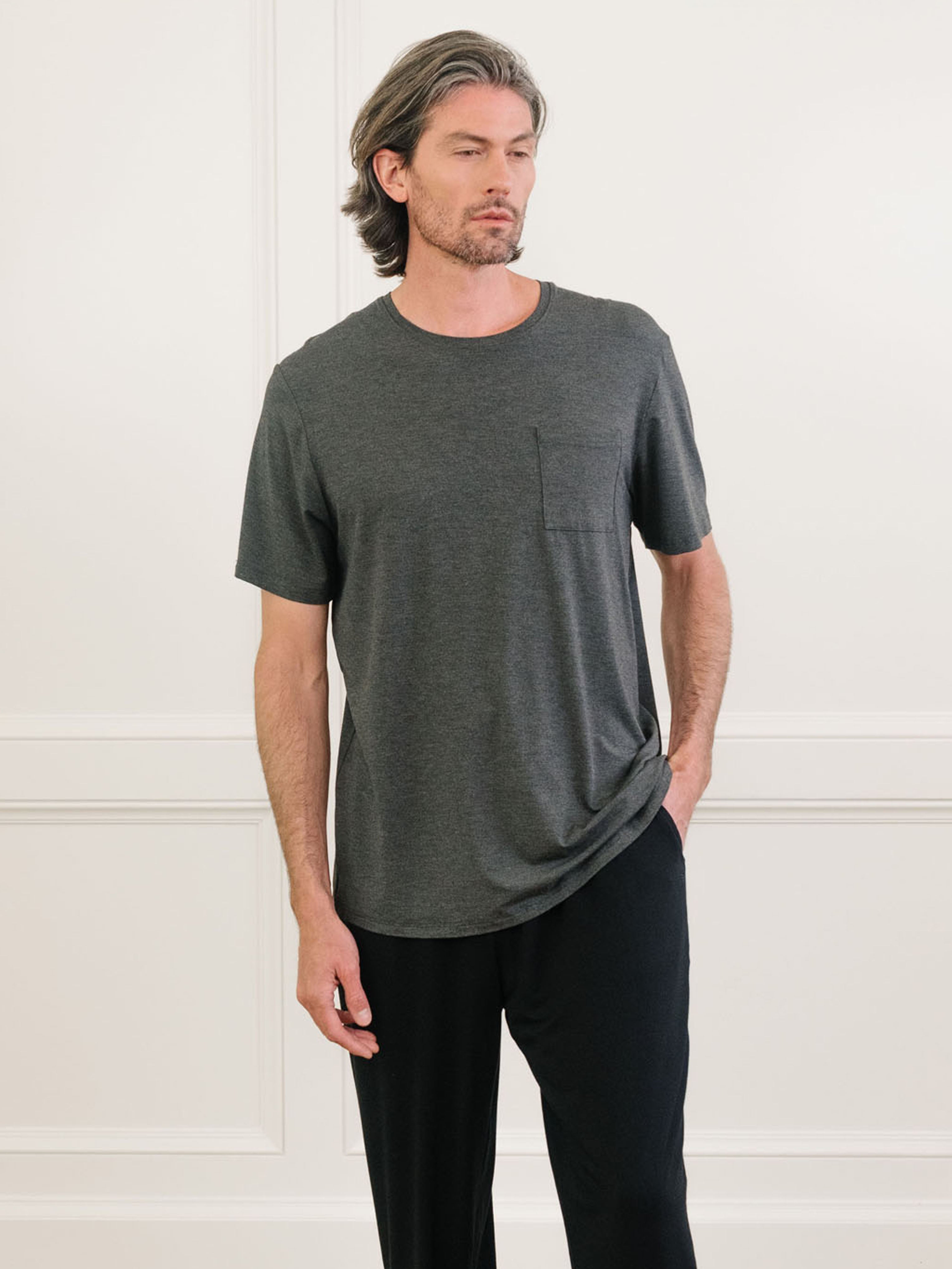 Charcoal Men's Stretch-Knit Bamboo Lounge Tee. A man is wearing the lounge tee in a well lit home.|Color:Charcoal