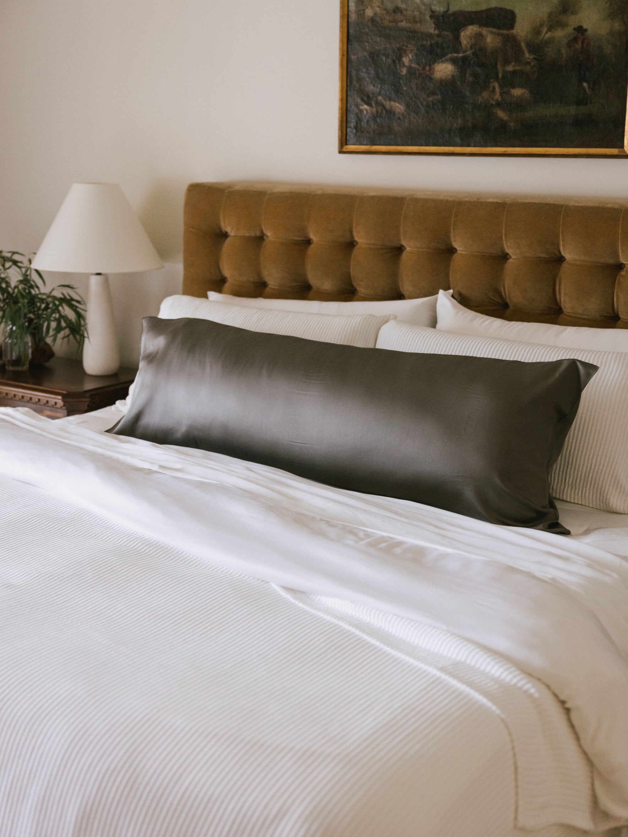 Body pillow with charcoal case on bed 