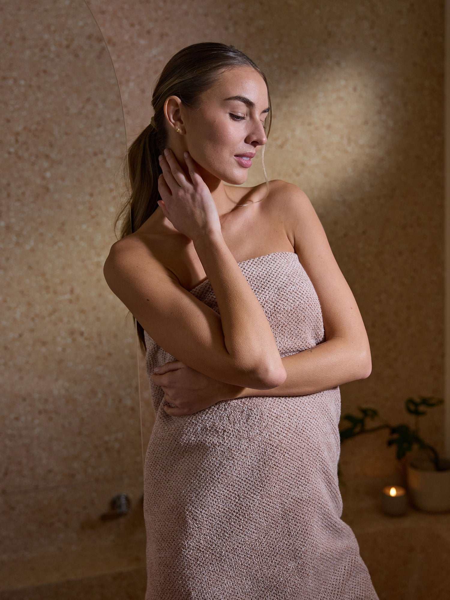 A woman is wrapped in a Nantucket Bath Sheet in Heathered Clay. 