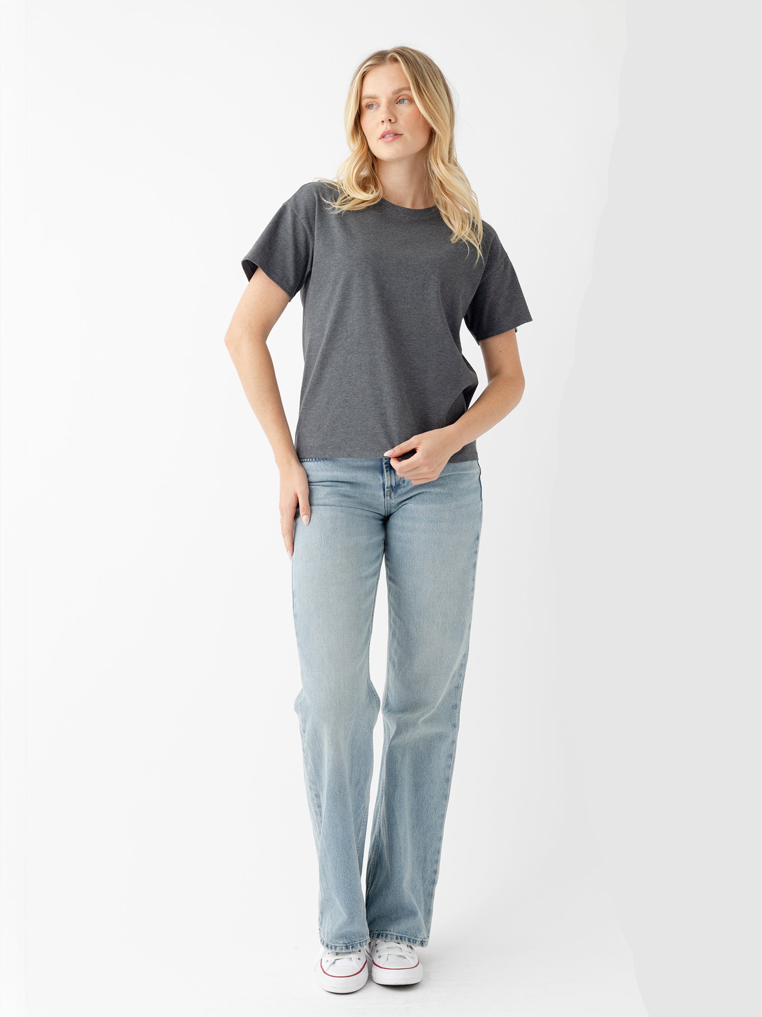 Woman wearing coal heather tee and jeans with white background 