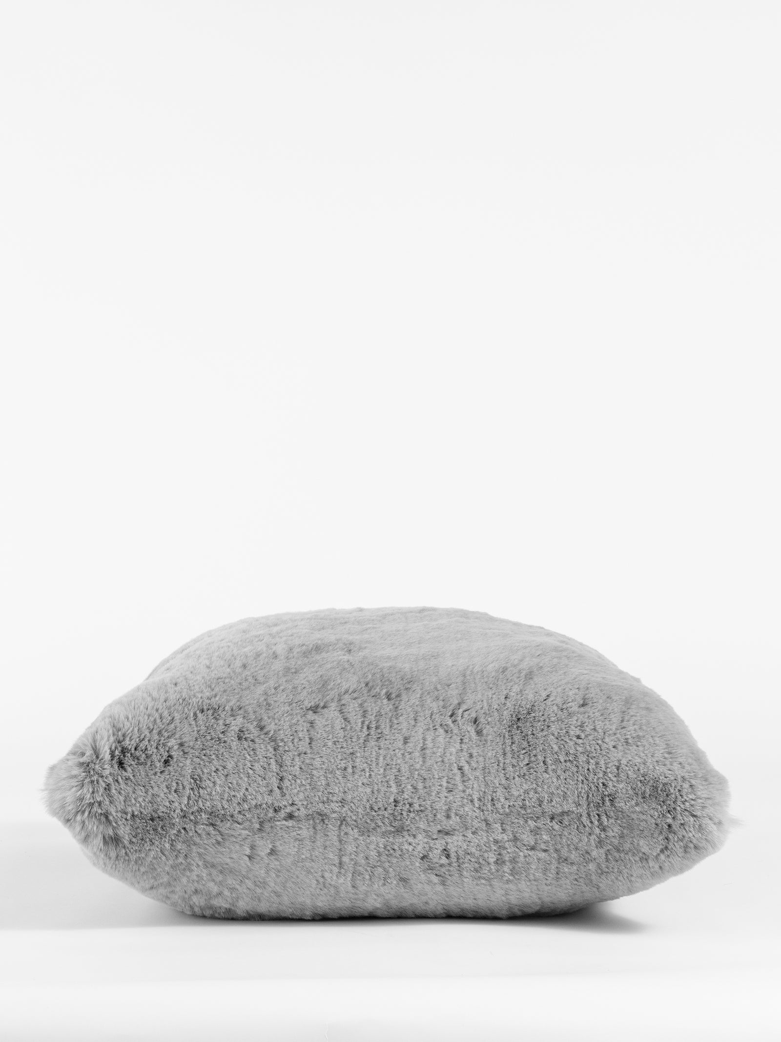 The Cuddle Pillow by Cozy Earth rests against a plain white background. With its smooth, plush texture, this fluffy gray pillow appears soft and comfortable. Its simple, neutral color enhances its cozy appeal. 